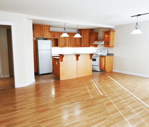 A kitchen with wooden cabinets and a white refrigerator.
