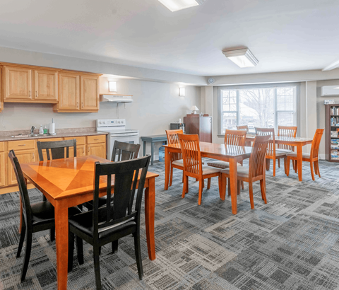 A kitchen with a dining table and chairs.