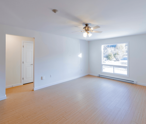 A room with a ceiling fan and a window.