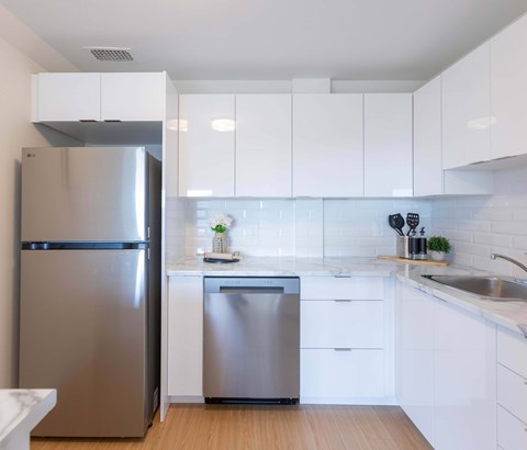 A modern kitchen with a stainless steel refrigerator and dishwasher.