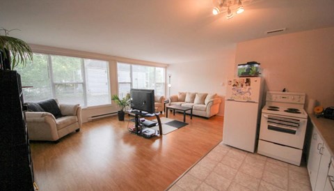 a living room with a stove and a refrigerator