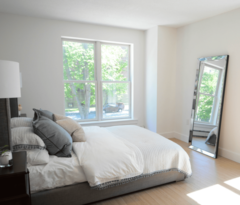 A bedroom with a large bed and a large window.