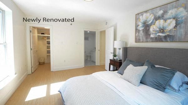 a bedroom with a bed and a painting on the wall