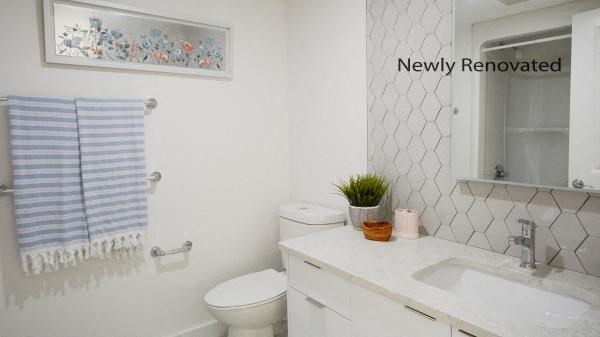 a white bathroom with a sink and a toilet
