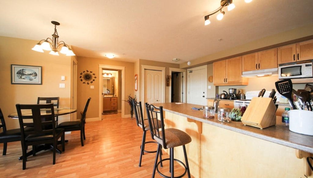 A kitchen with a table and chairs.