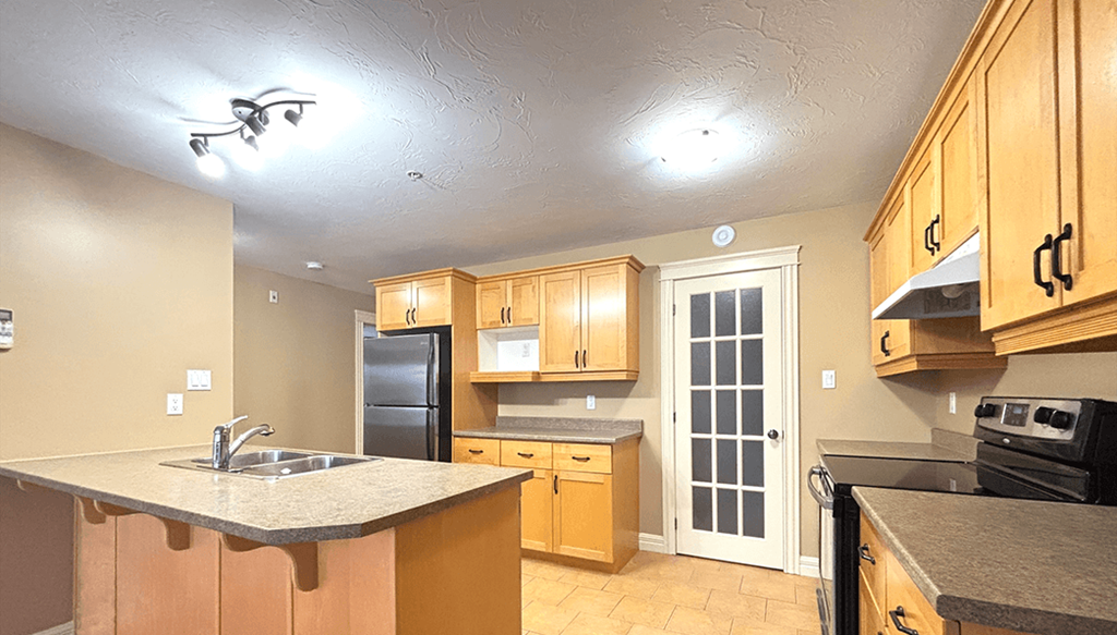 A kitchen with wooden cabinets and a granite countertop.