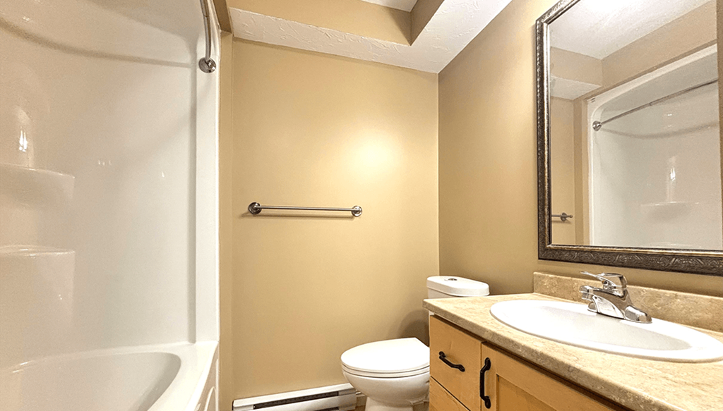 A bathroom with a toilet, sink, and bathtub.