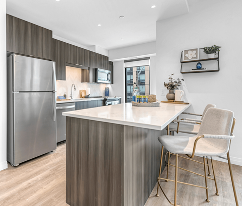 A modern kitchen with a stainless steel refrigerator and a white countertop.