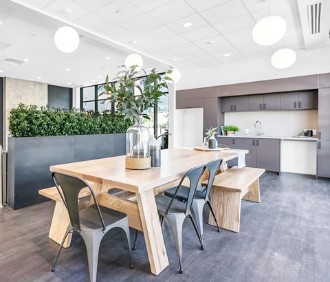 A modern dining area with a wooden table and chairs.