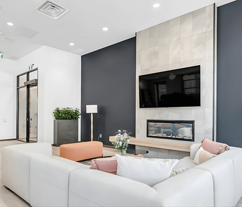 A modern living room with a white couch and a fireplace.