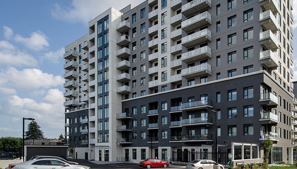 a large apartment building with cars parked in front of it