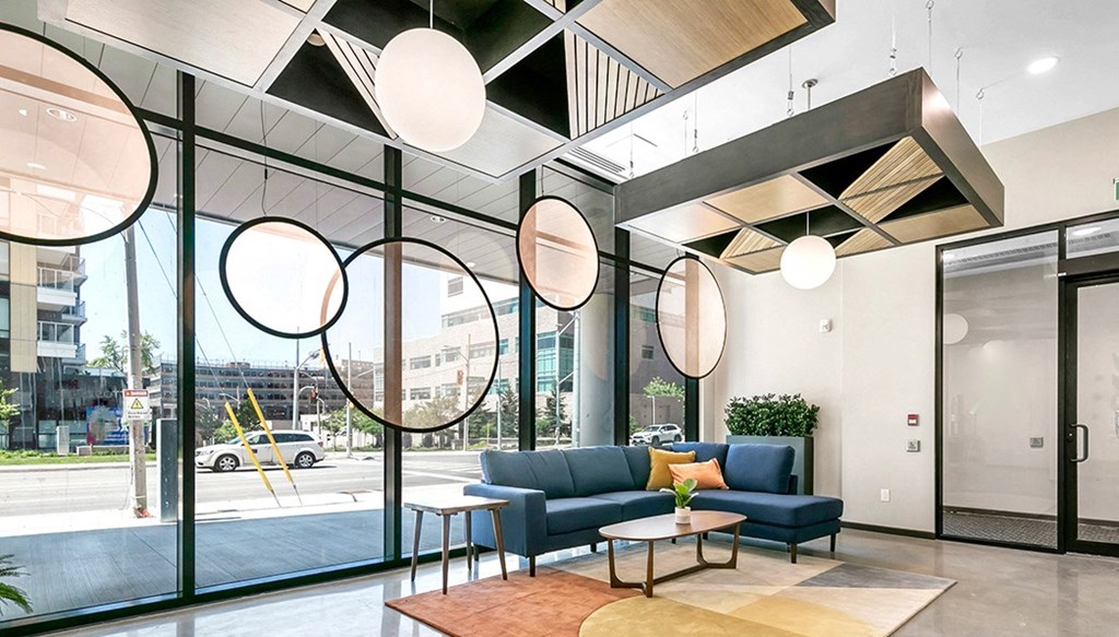 a living room with a couch and tables in front of a glass door