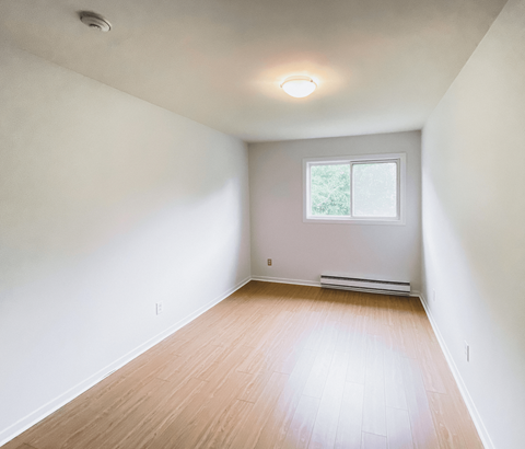 A room with a window and a radiator on the wall.
