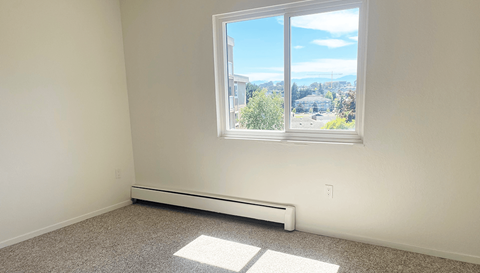 an empty room with a large window with a city view