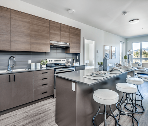 A modern kitchen with a large island and bar stools.