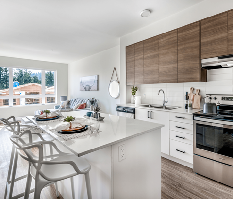 A modern kitchen with a dining table set for two.