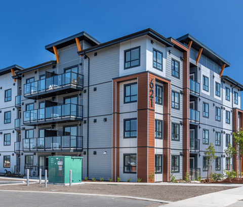 A modern apartment building with a mix of grey, brown, and blue tones.