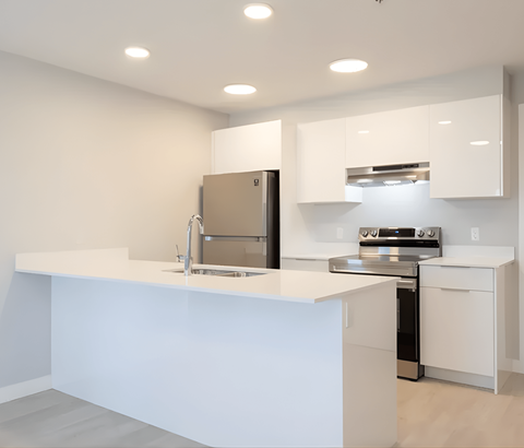 A modern kitchen with white cabinets and appliances.