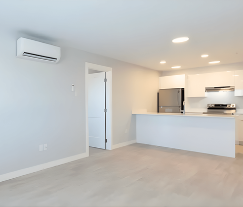 A modern kitchen with a white countertop and a stainless steel refrigerator.