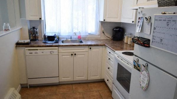 a kitchen with white cabinets and a stove and a window