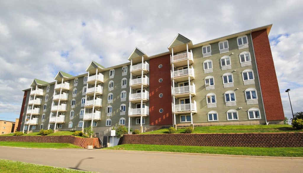 A large apartment building with multiple balconies and windows.