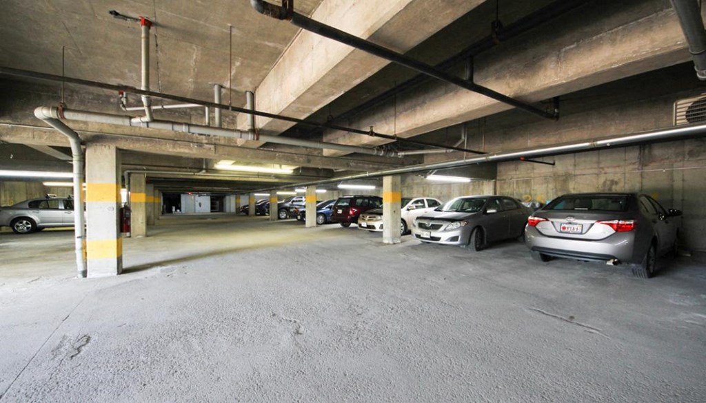 A parking garage with several cars parked in it.