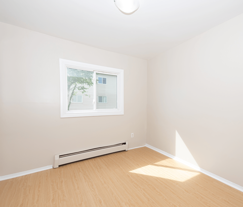 A room with a window and a radiator on the wall.