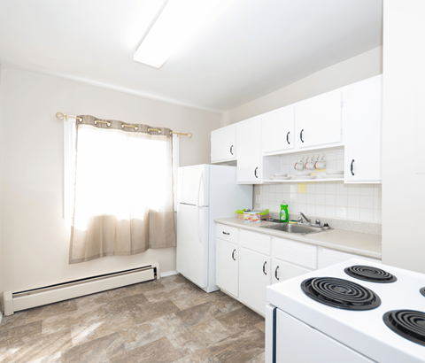 A kitchen with white appliances and cabinets.