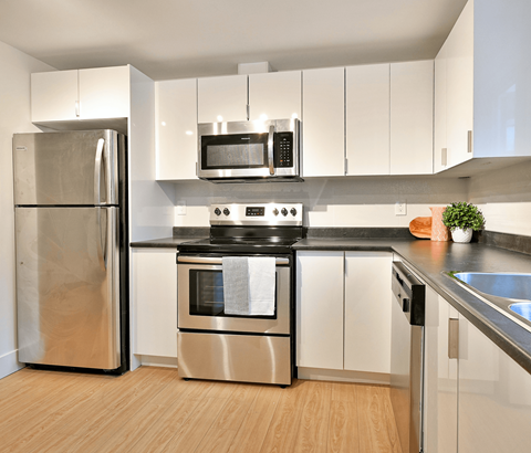 A modern kitchen with a stainless steel refrigerator and oven.