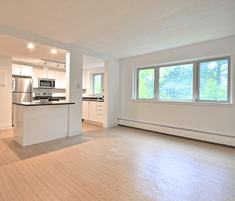 A kitchen with a refrigerator, microwave, and oven.
