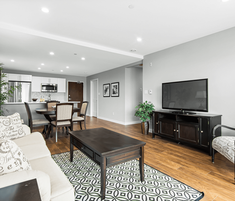 A modern living room with a black coffee table and a white sofa.