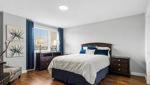 a bedroom with a bed and a window with blue curtains