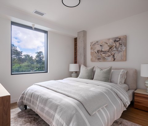 A bedroom with a large bed and a painting on the wall.
