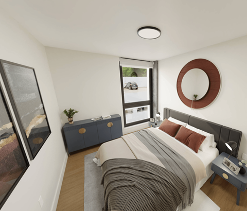 A bedroom with a large bed and a window overlooking a parking lot.