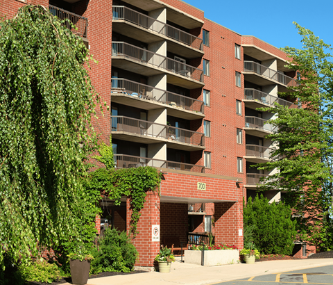 A red brick building with balconies and a parking sign.