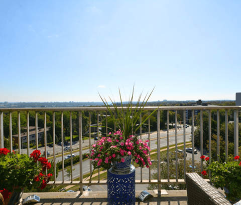 A balcony with a view of the street and buildings.