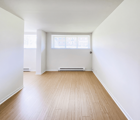 A room with wooden flooring and a window.