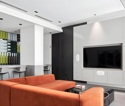 A modern living room with a television and orange sofas.
