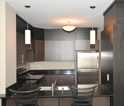 A modern kitchen with a stainless steel refrigerator and a sink.