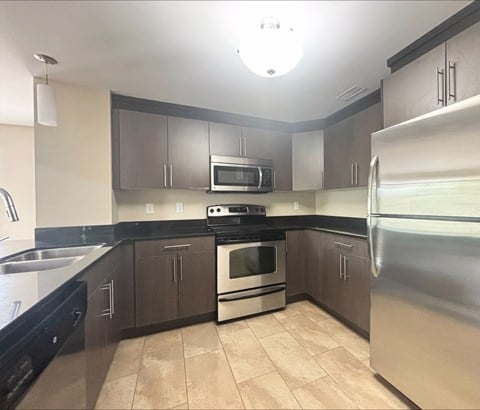 A kitchen with a stove, oven, refrigerator, and microwave.