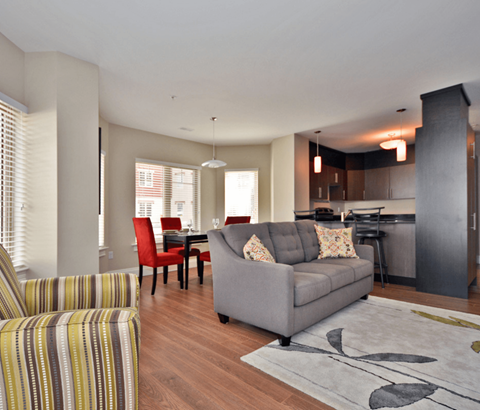 A living room with a grey couch and a striped armchair.