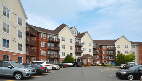 a parking lot with cars in front of an apartment building