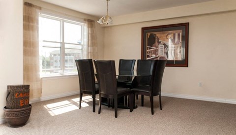 a dining room with a table and chairs and a window