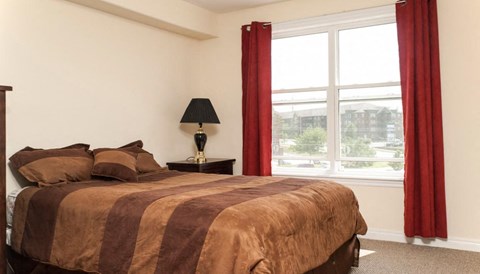 a bedroom with a bed and a large window