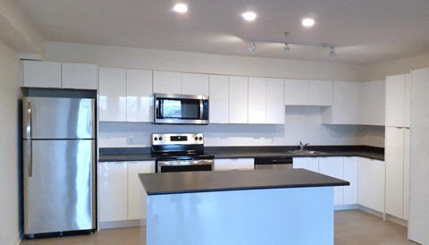 a kitchen with white cabinets and a stainless steel refrigerator