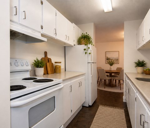 A kitchen with white cabinets and a stove top oven.