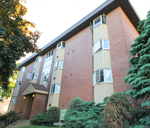 A red brick building with a balcony on the second floor.