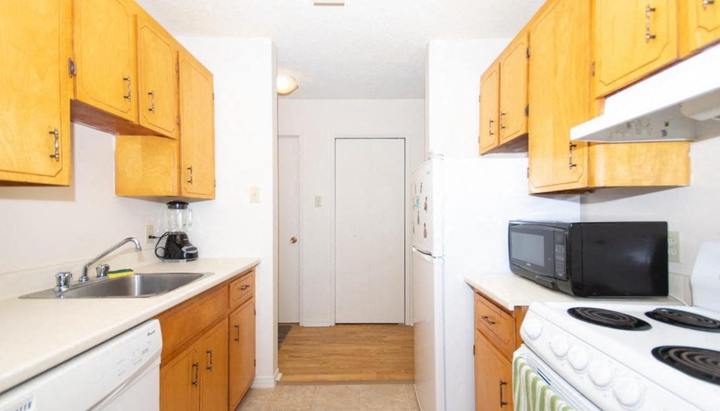 A kitchen with wooden cabinets and white appliances.