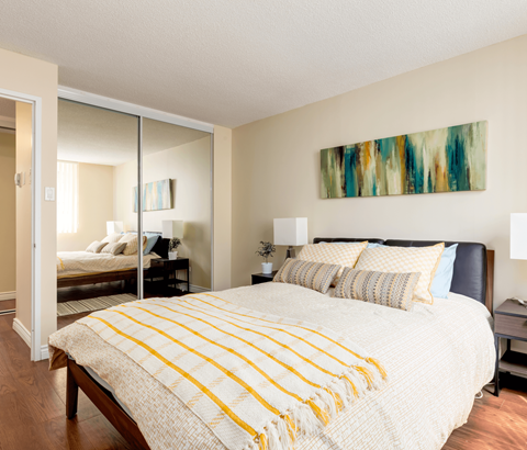 A bedroom with a large bed and a painting on the wall.