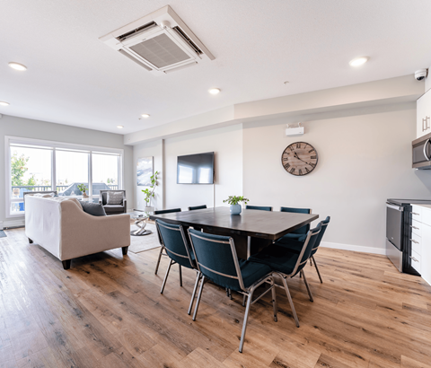 A modern dining room with a wooden table and chairs.